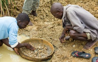 Recherche de diamants bruts dans une rivière avec un tamis