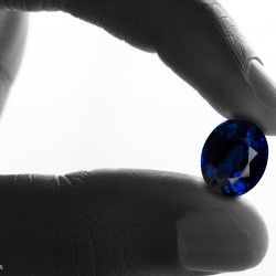 saphir bleu saphir bleu, taille ovale tenu entre deux doigts